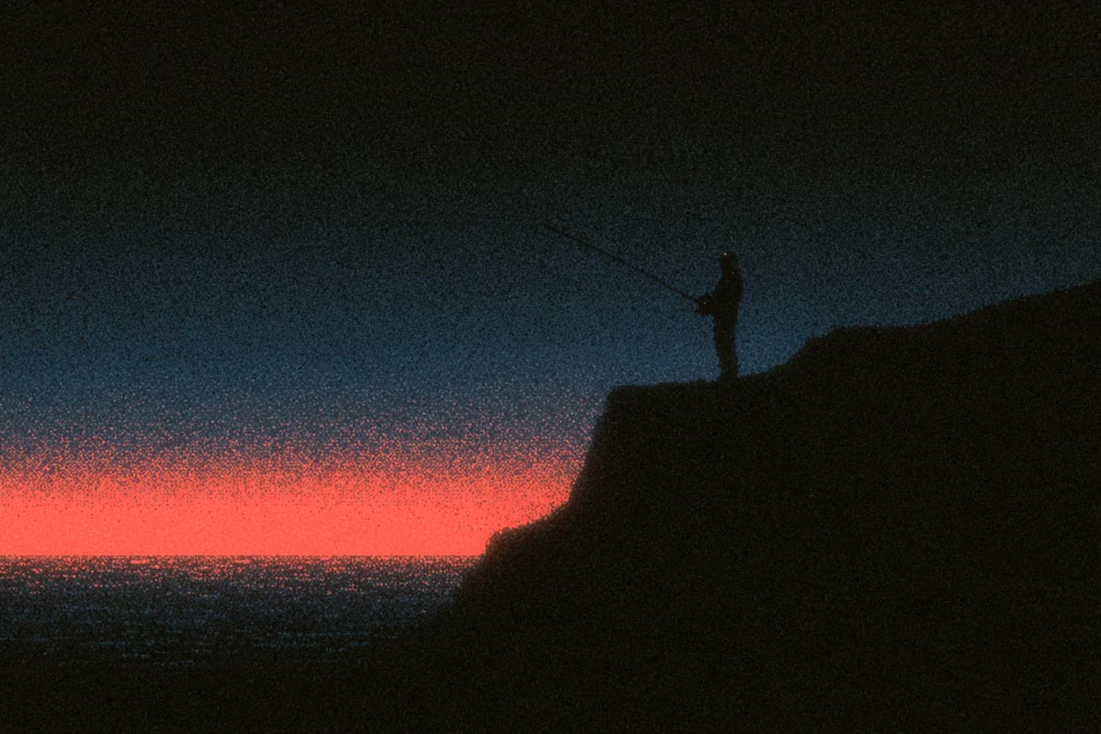 An angler casting a spinning rod from a rocky shore at dusk