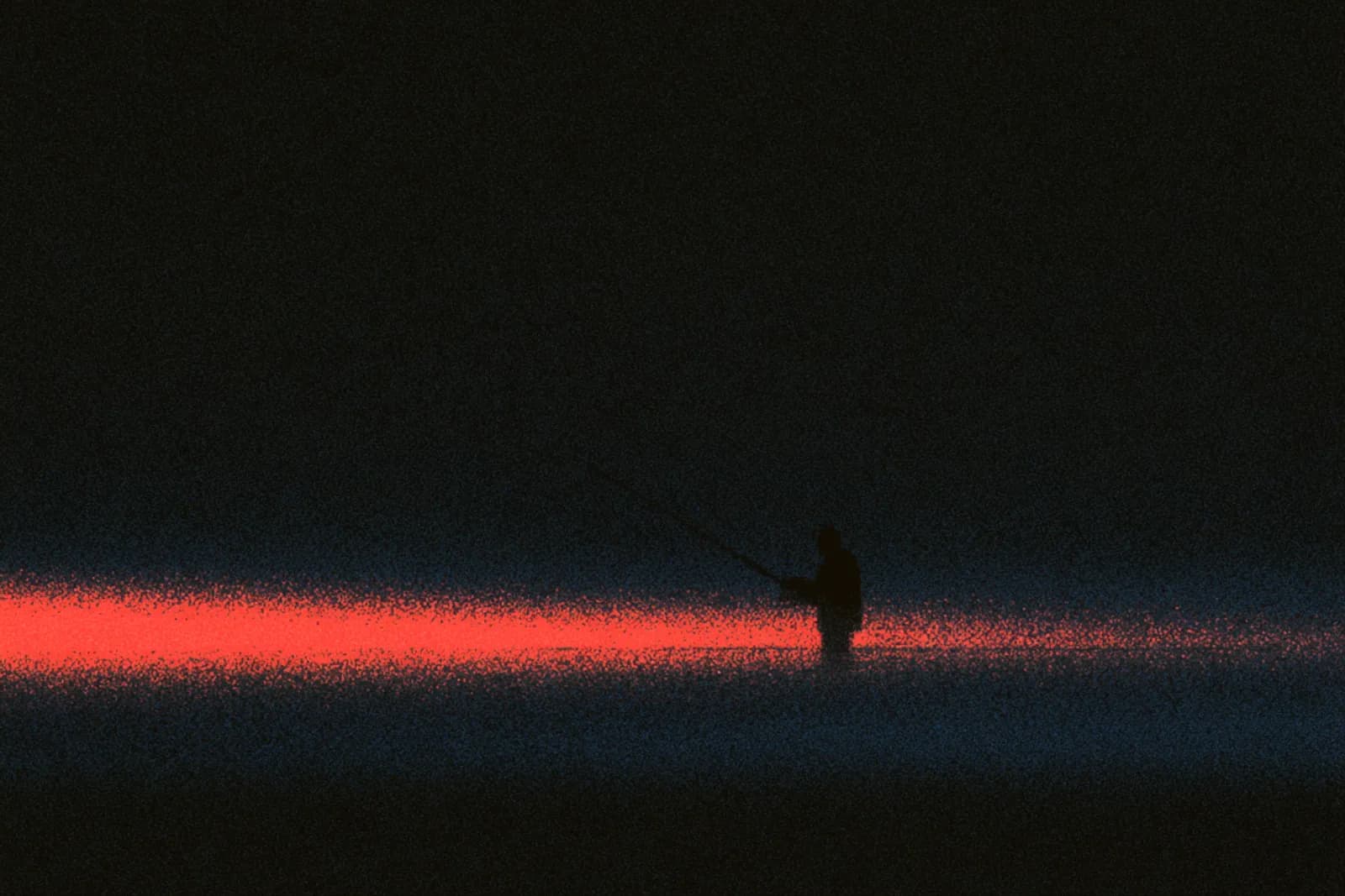 An angler wading a river at dawn